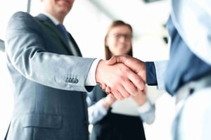 SIS_Two Professional Men In Suits Shaking Hands And Professional Woman In Glasses Smiling Watching